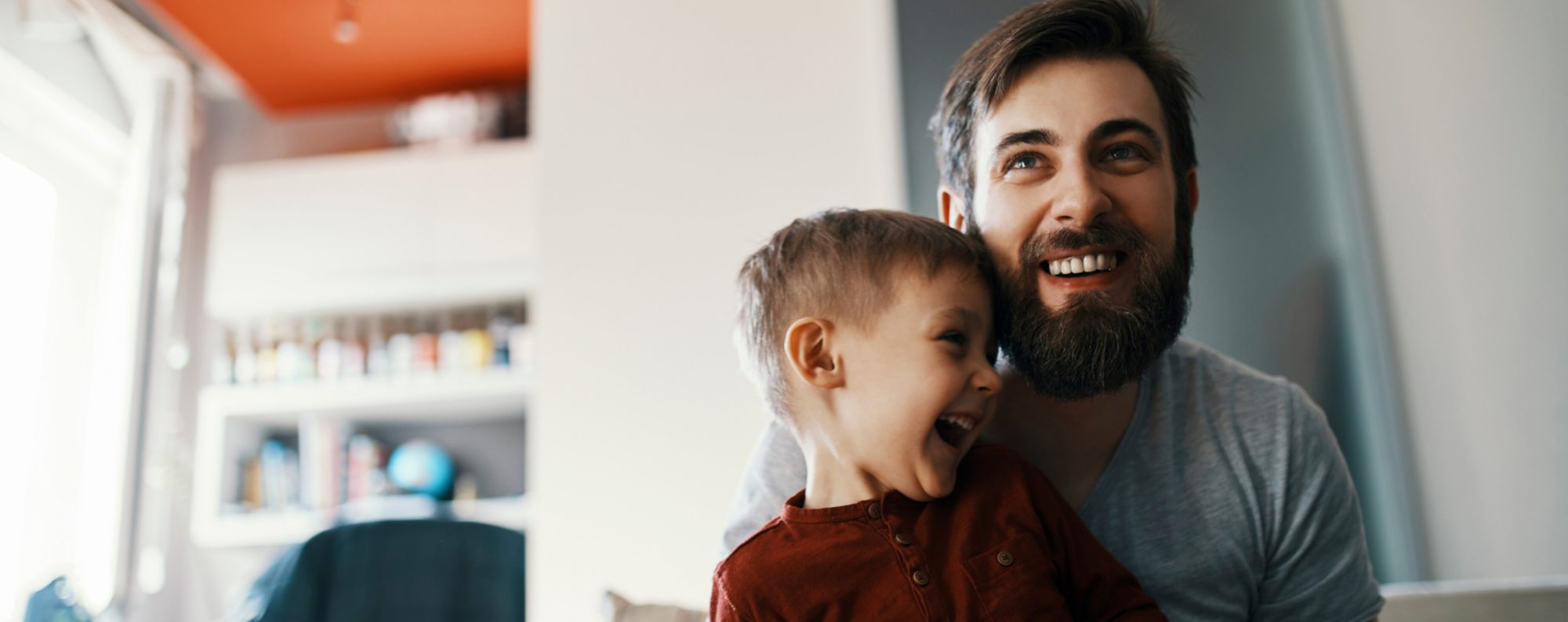 Man smiling while holding a child